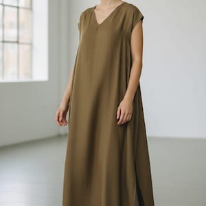 Peut inclure: Tasse en céramique blanche avec une anse noire, portant l'inscription "But First, Coffee" en noir. La tasse est présentée sur un fond flou, suggérant un cadre chaleureux.