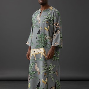 Puede incluir: Vestido gris de manga larga con estampado de animales tropicales con tucanes, cebras y leopardos. El vestido tiene cuello en V y una abertura lateral. El texto "Trend Trunk Syndicate" está en la parte inferior.