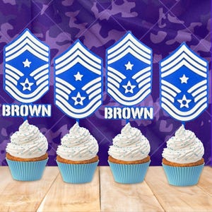 May include: Four cupcakes with white frosting and blue sprinkles sit below blue and white military rank insignia. The word "BROWN" is below two of the insignia. The background is a purple camouflage pattern.
