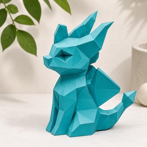 May include: A teal papercraft dragon figurine featuring a geometric, low-poly design. The creature is depicted in a seated position with pointed ears, folded wings, and a tail ending in a diamond-shaped tip, all constructed from angular paper panels.