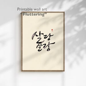Pode incluir: Arte de parede emoldurada com o texto "Fluttering" e caligrafia coreana. A obra apresenta caracteres pretos e decorados com flores sobre um fundo creme, emoldurados em uma moldura de madeira. O canto superior esquerdo diz "Arte de parede imprimível".