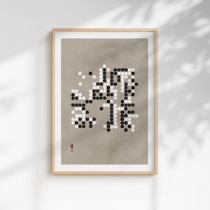 Peut inclure: Impression d'art encadrée avec un design minimaliste de points noirs et blancs disposés en un motif ressemblant à des caractères japonais. L'œuvre est posée sur un fond neutre et encadrée dans du bois clair. Un petit sceau rouge est dans le coin inférieur gauche.