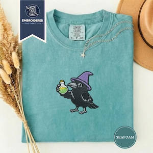 May include: A white ceramic mug with a black handle and the text "But First, Coffee" in a handwritten style. The mug is on a white surface. The mug is likely for hot beverages.