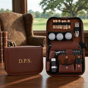 Puede incluir: Un kit de accesorios de golf de cuero marrón con cierre de cremallera, que incluye pelotas de golf, tees, un herramienta para reparar el césped y otros accesorios. También se incluye un estuche a juego con las iniciales "D.P.S.".