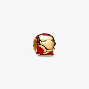 Könnte beinhalten: Ein Charm-Anhänger in Form eines stilisierten Helms mit einer goldfarbenen Metallfront und leuchtend roten Emaille-Seiten. Der Helm verfügt über schmale, horizontale Augenschlitze und einen ausgeprägten Mundbereich zur Befestigung an Ketten.