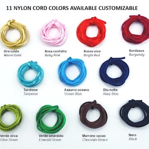 May include: Eleven coiled nylon cords in various colors including warm gold, baby pink, bright red, burgundy, turquoise, ocean blue, navy blue, olive green, emerald green, chocolate brown, and black, labeled with their respective color names.