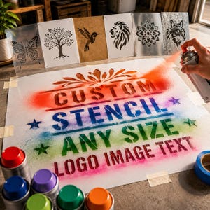 Könnte beinhalten: Eine große weiße Schablonenfolie mit dem Text CUSTOM STENCIL ANY SIZE LOGO IMAGE TEXT in einem regenbogenfarbenen Sprühfarbeneffekt. Mehrere kleinere Schablonen mit Motiven von Schmetterling, Baum, Kolibri, Löwe, Mandala und Wolf sind im Hintergrund angeordnet, begleitet von mehreren bunten Sprühdosen.