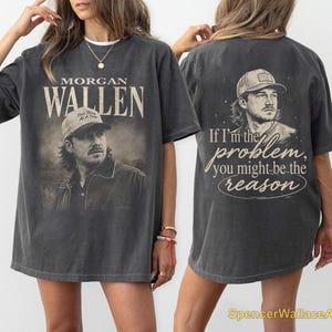 Peut inclure: Un t-shirt gris anthracite à manches courtes avec un graphisme vintage de Morgan Wallen sur le devant et son nom en grandes lettres. Le dos présente un portrait de Morgan Wallen avec le texte If I'm the problem, you might be the reason.
