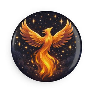 May include: A round button featuring a golden phoenix rising against a dark night sky filled with stars. The phoenix has outstretched wings and a fiery tail, with a gradient of orange and yellow hues. The button has a glossy finish.