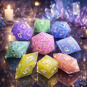 Könnte beinhalten: Eine Sammlung farbenfroher, edelsteinartiger Würfel in verschiedenen Formen und Größen. Die Würfel sind in Lila, Grün, Blau, Rosa, Gelb und Orange gehalten, mit goldfarbenen Zahlen und dekorativen Akzenten. Für Tischspiele.