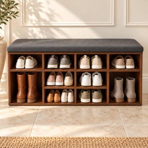 May include: A rectangular wooden shoe storage bench with a dark gray upholstered seat cushion. The unit features eight open cubby compartments organized in two rows, filled with various styles of footwear including sneakers, boots, and flats.