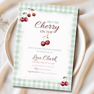 Könnte beinhalten: Eine Babyparty-Einladung mit einem grün-weiß karierten Rand und Kirschillustrationen. Der Text lautet "she's the Cherry on Top" und enthält Details für Lou Clarks Babyparty, einschließlich Datum, Uhrzeit und Ort.