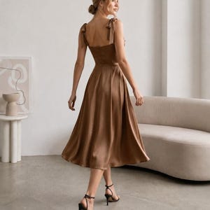 Elegante vestido midi con tirantes de lazo, escote cuadrado y corte en A, ideal para invitadas de boda. imagen 1