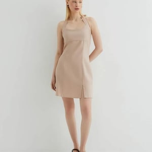 Minivestido de lino con escote halter, espalda con lazo, ajustado, estilo veraniego neutro.