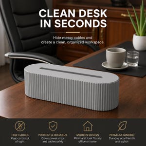 Puede incluir: Una caja de gestión de cables gris claro con un diseño acanalado, sobre un escritorio de madera. El texto "CLEAN DESK IN SECONDS" está en la parte superior. La caja está diseñada para ocultar cables y crear un espacio de trabajo organizado. El texto adicional incluye "HIDE CABLES", "PROTECT & ORGANIZE", "MODERN DESIGN" y "PREMIUM BAMBOO".