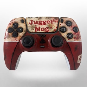Peut inclure: Une manette de jeu vidéo personnalisée avec une esthétique vintage et vieillie. La manette présente une palette de couleurs rouge et crème avec des éclaboussures ressemblant à du sang. Le texte "JUGGER NOG" est affiché en évidence en haut au centre. La manette a des boutons noirs.