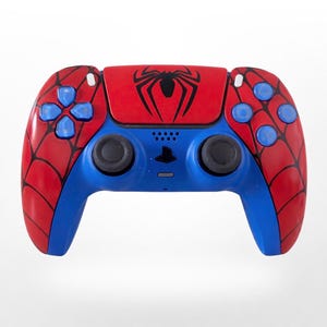 Mando de PS5 pintado a mano: mando con diseño de telaraña en rojo, negro y azul, con estilo retro de superhéroe de cómic.