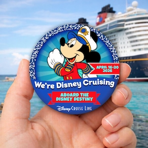 May include: A round blue button featuring Mickey Mouse in a captain's uniform, with the text "We're Disney Cruising" and "Aboard the Disney Destiny". The button also includes the dates "April 16-20 2026" and the Disney Cruise Line logo.