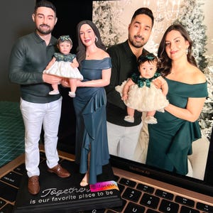 Könnte beinhalten: Ein Familienfiguren-Set mit Laptop-Hintergrund. Die Figuren zeigen eine vierköpfige Familie in formeller Kleidung. Auf der Basis der Figuren steht "Together is our favorite place to be". Der Hintergrund zeigt ein Familienfoto.