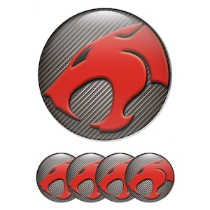 May include: A set of Thundercats logo stickers. The stickers feature a red Thundercats logo on a gray carbon fiber background. The set includes one large sticker and four smaller stickers.