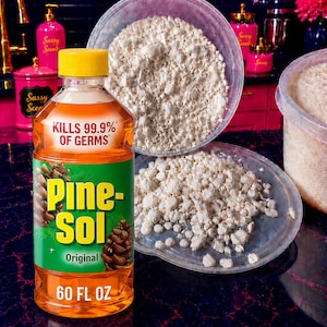 May include: A 60 fl oz bottle of orange Pine-Sol Original cleaner with a yellow cap, featuring the text KILLS 99.9% OF GERMS. Next to it are two clear plastic containers filled with small, irregular, off-white solid granules or wax pieces.