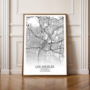 Könnte beinhalten: Eine gerahmte Schwarz-Weiß-Karte von Los Angeles, Kalifornien, mit dem Straßennetz der Stadt. Der Text "LOS ANGELES - United States - City of Dreams" befindet sich unten. Der Rahmen hat eine warme braune Farbe.