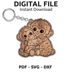 Pode incluir: Porta-chaves de madeira com corrente e argola prateadas, com dois macacos de desenho animado a abraçar-se. Os macacos são castanhos com contornos pretos. O texto "DIGITAL FILE Instant Download" e "PDF - SVG - DXF" estão presentes.