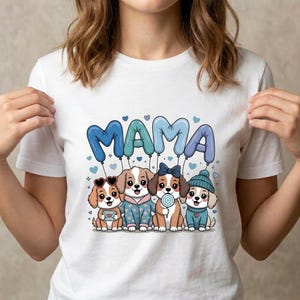 May include: White t-shirt featuring a graphic of four cartoon puppies with the word "MAMA" in blue balloon letters. The puppies are wearing various accessories, including sunglasses, a bow, and a hat.