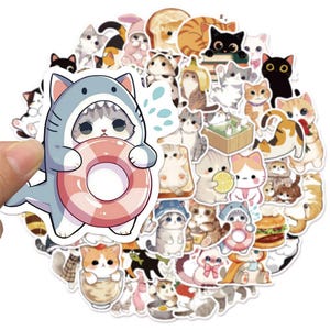 May include: A collection of die-cut vinyl stickers featuring various cartoon cats in diverse poses, including a cat wearing a shark costume holding a pink inner tube, cats in food items, cats with fruit, and cats in various outfits with colorful designs.