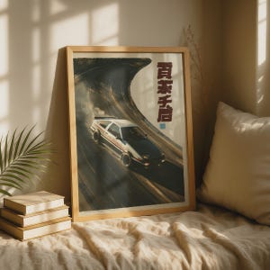 Puede incluir: Un póster vertical enmarcado que muestra un coche deportivo blanco y negro derrapando en una carretera de asfalto curva. El coche está orientado hacia la parte inferior derecha, con humo de neumáticos visible. Texto japonés vertical en rojo oscuro está impreso en el lado derecho.