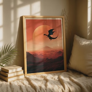 Puede incluir: Una lámina de arte mural rectangular enmarcada que muestra la silueta oscura de un dragón volando frente a un gran sol naranja brillante. El paisaje inferior presenta cadenas montañosas superpuestas en tonos rojos y marrones profundos.