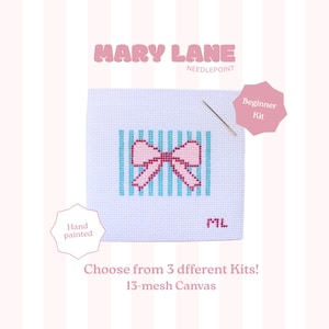 May include: A white needlepoint canvas featuring a light blue striped background with a pink bow design in the center. The canvas includes a needle, the text MARY LANE NEEDLEPOINT, Beginner Kit, Hand painted, and ML in the corner.