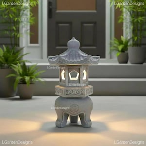 May include: A light grey stone-coloured lantern with a pagoda-style roof, featuring a pentagonal cutout window, intricate carved patterns on the midsection, and a rounded base with three legs, emitting a warm glow from the central chamber.