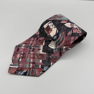Può includere: Una cravatta con un motivo astratto scuro e multicolore con forme geometriche, inclusi segmenti bordeaux, neri e verde acqua. Il design incorpora sottili linee scure scarabocchiate su uno sfondo a scacchi nei toni del rosso e del grigio spento.