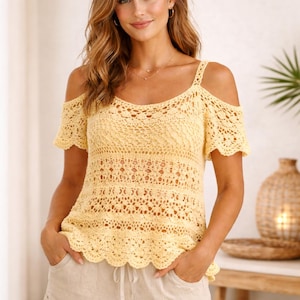Könnte beinhalten: Ein hellgelbes Häkeltop mit Rundhalsausschnitt und kurzen Ärmeln. Das Top hat ein Schulter-Ausschnitt-Design und einen gewellten Saum. Das Häkelmuster umfasst offene und strukturierte Details, die einen zarten und luftigen Look erzeugen.