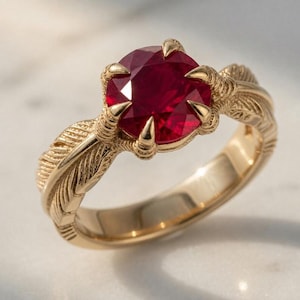 Anel em ouro 14K com garra de corvo e rubi, entalhe de pena, estilo gótico, ideal para presentear.