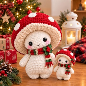 May include: Two crochet mushroom dolls with red caps featuring white spots, cream-colored bodies, and black eyes. Each doll wears a red, green, and white striped scarf adorned with a small green holly leaf and red berry accent on the side.
