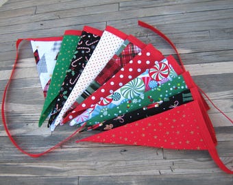 May include: A Christmas banner with 12 red, green, and white fabric pennants featuring various holiday patterns, including candy canes, snowflakes, and trees.