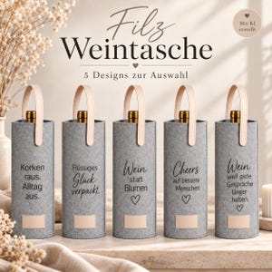 Könnte beinhalten: Fünf zylindrische Weintaschen aus grauem Filz mit hellbeigen Ledergriffen und Etiketten. Jede Tasche trägt einen individuellen schwarzen Text: "Korken raus. Alltag aus.", "Flüssiges Glück verpackt.", "Wein statt Blumen", "Cheers auf bessere Menschen" und "Wein weil gute Gespräche länger halten."