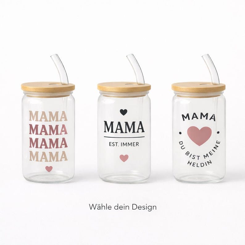 May include: Three clear glass tumblers with bamboo lids and glass straws. The first features the word MAMA in repeating colors with a small heart. The second says MAMA EST. IMMER with hearts. The third says MAMA DU BIST MEINE HELDIN with a heart.
