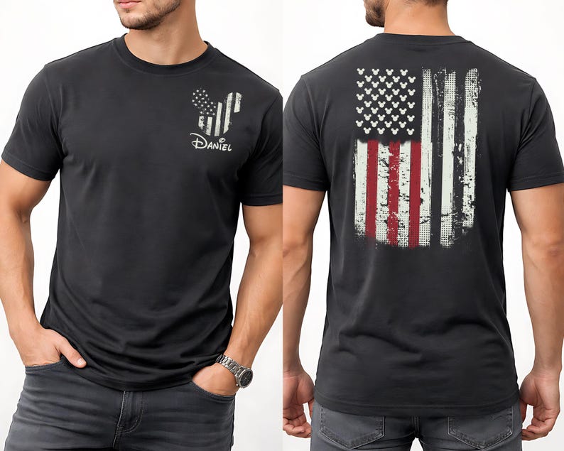 K&ouml;nnte beinhalten: Dunkelgraues T-Shirt mit einem abgenutzten amerikanischen Flaggen-Design auf dem R&uuml;cken. Die Vorderseite zeigt eine von Mickey Mouse inspirierte Flaggen-Grafik und den Namen "Daniel" in Wei&szlig;. Das Shirt hat kurze &Auml;rmel und einen Rundhalsausschnitt.