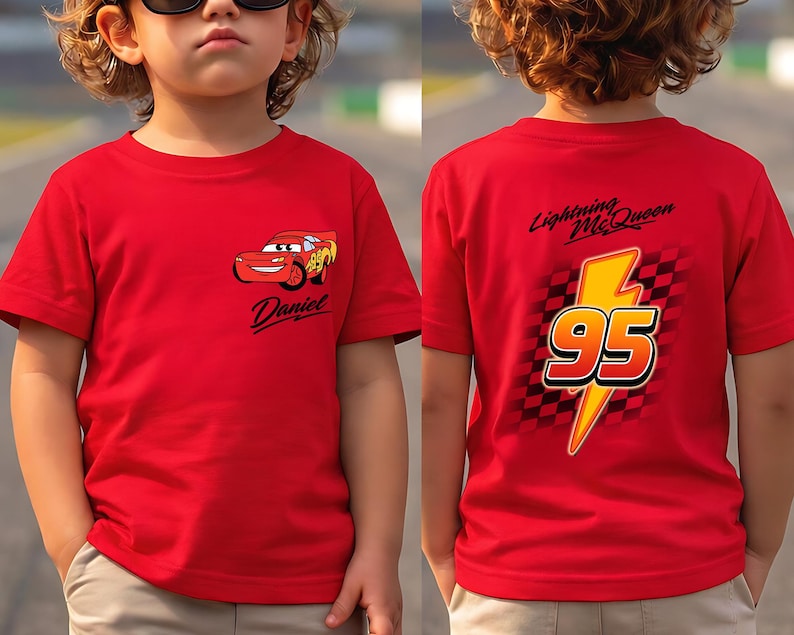 Pu&ograve; includere: Maglietta rossa con Saetta McQueen del film Cars. La parte anteriore mostra il personaggio e il nome "Daniel". Il retro presenta un fulmine giallo con il numero "95" e il testo "Lightning McQueen".