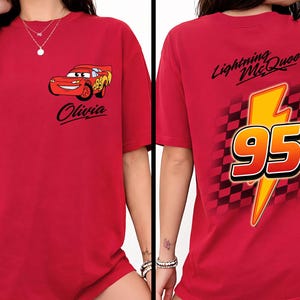 Pu&ograve; includere: T-shirt rossa con Lightning McQueen del film Cars. La parte anteriore mostra il personaggio e il nome "Olivia". Il retro mostra un fulmine giallo con il numero "95" e la scritta "Lightning McQueen".