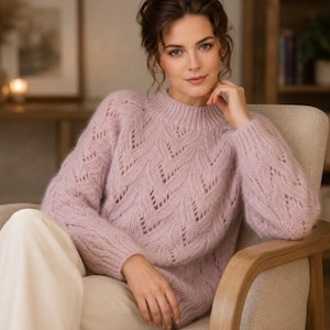 May include: A light pink long-sleeved jumper featuring a textured chevron knit pattern with openwork detailing, a ribbed mock neck collar, and ribbed cuffs. The garment is crafted from a soft, fuzzy yarn and has a relaxed fit throughout the body.