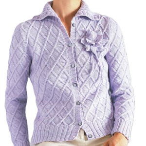 May include: A light purple, button-down cardigan sweater with a diamond pattern and a decorative flower on the chest. The sweater has a collared neckline and long sleeves. The buttons are a matching light purple color.