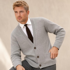 May include: A light grey knit cardigan with a V-neckline, long sleeves, and three dark brown buttons down the front. The cardigan features two front patch pockets and is worn over a crisp white collared shirt with a dark brown textured necktie.