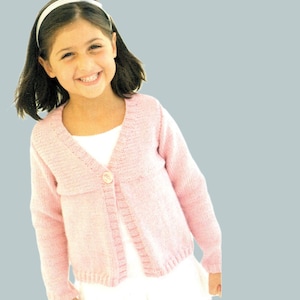 Peut inclure: Un cardigan rose clair tricoté avec une fermeture à bouton unique. Le pull a des manches longues et une encolure en V. Le cardigan est porté sur un vêtement blanc. Le fond est bleu clair uni.