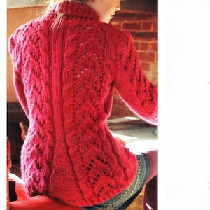 May include: A red knitted sweater with a high collar and intricate cable and openwork patterns. The back of the sweater is visible, showcasing the detailed design. The sweater is a vibrant shade of red, perfect for cooler weather.