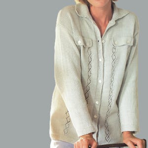 Può includere: Camicia in maglia verde chiaro a maniche lunghe con colletto e chiusura con bottoni. La camicia presenta due piccole tasche sul petto e ritagli decorativi a forma di diamante. Le maniche sono lunghe e la camicia è realizzata in maglia morbida e strutturata.