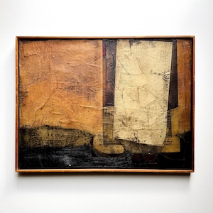 May include: Abstract mixed media artwork in a wooden frame. The artwork features a collage of textured paper in shades of brown, beige, and black. The word "DON'T" is visible on a piece of paper. The overall aesthetic is rustic and artistic.